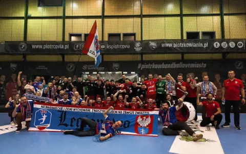 Drużyna KPR Legionowo świętuje zwycięstwo, trzymając transparent z herbem i hasłem.