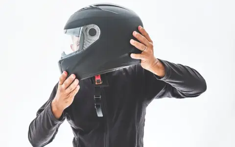 Persona indossa un casco integrale nero, pronto per un giro in moto.