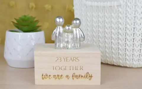 Srebrna figurka rodziny na drewnianym pudełku z napisem "23 YEARS TOGETHER We are a family". Idealny prezent na 23 rocznicę ślubu.