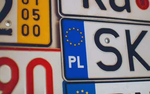 Kolekcja tablic rejestracyjnych, w tym polska z symbolem UE i oznaczeniem PL.