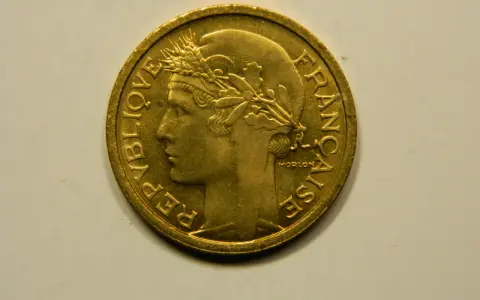 Une pièce de 1 franc 1948, en or, avec le profil d'une femme couronnée de blé. "République Française" est gravé sur le pourtour.