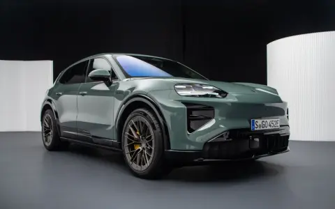 Zielony elektryczny Porsche Macan na ciemnym tle.