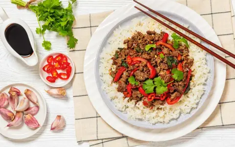 Delicioso arroz con carne picada, pimientos rojos y cilantro fresco. Acompañado de salsa de soja, chiles y ajos.