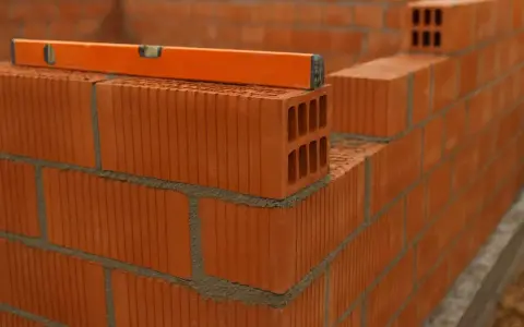 Nivel de burbuja sobre ladrillos huecos, mostrando la construcción de varios tipos de tabiques interiores.