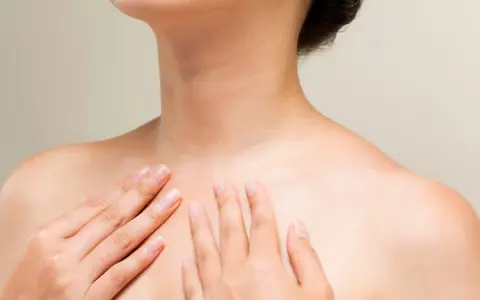 Mains caressant le cou et le décolleté, une invitation à muscler son cou pour une posture élégante.