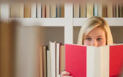Blondynka z książką w rękach, ukryta za nią, jakby przekraczała granicę zofia nałkowska.