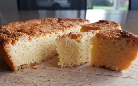 Un delicioso pastel bretón, dorado y esponjoso, cortado en porciones sobre una tabla de madera.