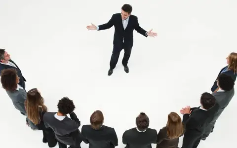 Un líder inspira a su equipo. Un grupo de personas en círculo escuchan atentamente a un hombre que demuestra master liderazgo y gestión de equipos.
