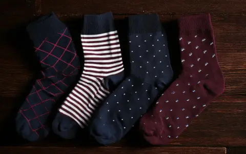 Quattro paia di calzini da uomo con fantasie diverse: rombi, righe, pois. Perfetti da abbinare a un abito elegante.