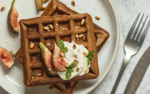Gesunde Waffeln Rezept: Zwei Schoko-Waffeln mit Joghurt, Feigen, Pinienkernen und Minze. Ein Genuss!