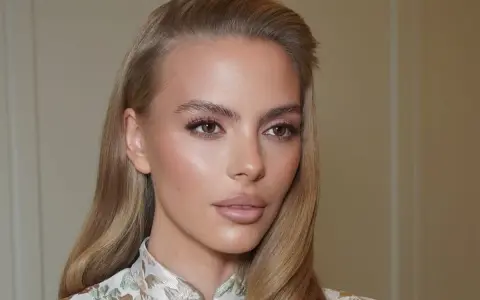 Delikatny makijaż podkreśla urodę kobiety, a jej skóra ma subtelny, **kolor perłowy** blask.