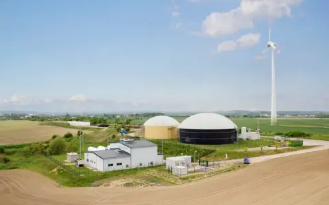 Biogasanlage mit großen Speichern und Windrad. Hier wird Energie erzeugt und für den biogas transportieren vorbereitet.