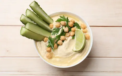 Krämig hummus med kikärtor, persilja, gurkstavar och lime. Ett enkelt hummus recept för en god dipp.