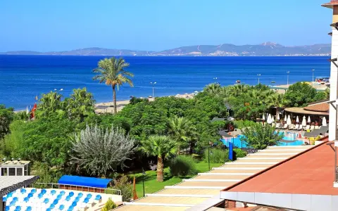 Widok na club cactus paradise: turkusowe morze, plaża, palmy, basen i budynki hotelowe.