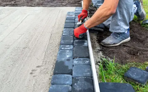 Układanie kostki brukowej na podsypce piaskowej to kluczowy etap, by wiedzieć, na czym postawić garaż blaszany.