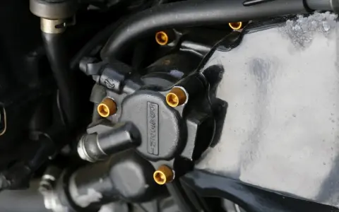Elementy układu hydraulicznego motocykla, widoczna regulacja pedału sprzęgła hydraulicznego.