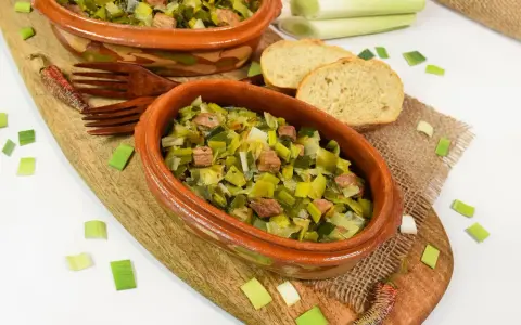 Zwei Terrinen mit Lauchgemüse und Fleischstücken, serviert mit Brot. Ein leckeres Beispiel für Lauch Rezepte.