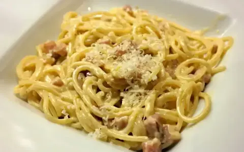 Pyszne spaghetti carbonara z chrupiącym boczkiem, kremowym sosem i parmezanem. Idealne danie dla miłośników włoskiej kuchni.