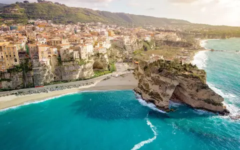 Panoramica mozzafiato delle calabria spiagge con case colorate aggrappate alle scogliere e un mare cristallino.