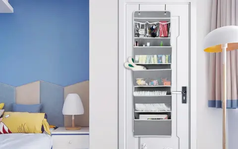Grauer **Pocket Schrank** an der Tür mit vielen Fächern, gefüllt mit Kosmetik, Spielzeug und Windeln.