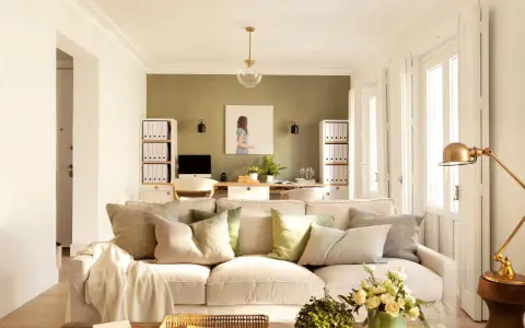 Ideas pintar salón en dos colores: pared verde texturizada y paredes blancas luminosas. Sofá beige, mesa de centro rústica, plantas y arte.