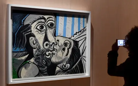 Un visitante captura con su móvil uno de los icónicos cuadros de Picasso, un beso en blanco y negro con toques de azul.