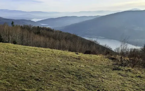 Widok na jezioro i góry w Beskidach. Idealne miejsce na krótkie szlaki w Beskidach, gdzie można podziwiać malownicze krajobrazy.