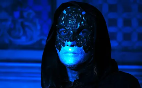 Volto mascherato con illuminazione blu intensa, un'immagine che evoca mistero e terrore, perfetta per i film horror più visti.