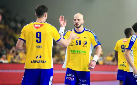 Piłkarze ręczni w żółtych koszulkach z numerami 9 i 50 świętują udany mecz vive.
