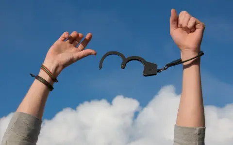 Uwolnione ręce z kajdanek symbolizują wolność od nałogu. Detoks narkotykowy NFZ daje szansę na nowe życie.