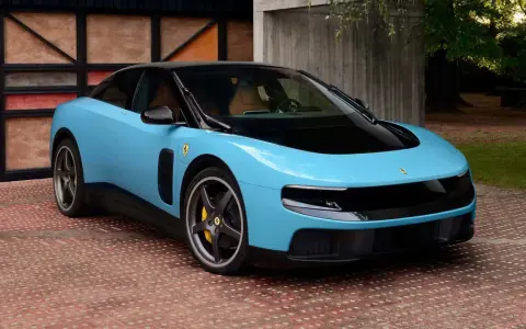 Ein hellblauer Ferrari mit schwarzem Dach und Felgen steht auf einem roten Ziegelstein-Muster. Neue Ferrari-Nachrichten über dieses Modell sind heiß begehrt.