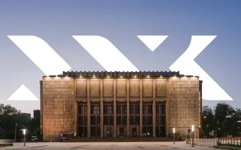 Monumentalna fasada Muzeum Narodowego w Krakowie przy Alei 3 Maja, oświetlona wieczorem.