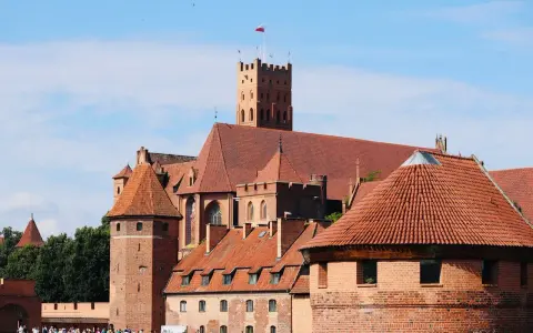 Zamek w Malborku, wpisany na listę **UNESCO Polska**, to imponująca twierdza z czerwonej cegły z charakterystycznymi wieżami i dachami.