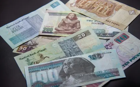 Egipskie funty, od 1 do 200, leżą na czarnym tle. Planujesz podróż i zastanawiasz się, jakie dolary do Egiptu? Lepiej zabrać funty!