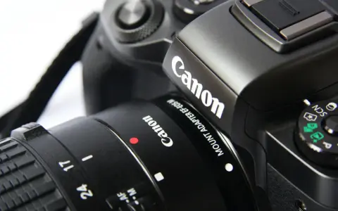 Zbliżenie na czarny aparat cyfrowy Canon z obiektywem.