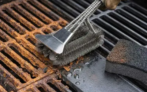 Cepillo metálico limpiando parrilla barbacoa oxidada. Un guante marrón sujeta el cepillo mientras elimina el óxido y la suciedad.