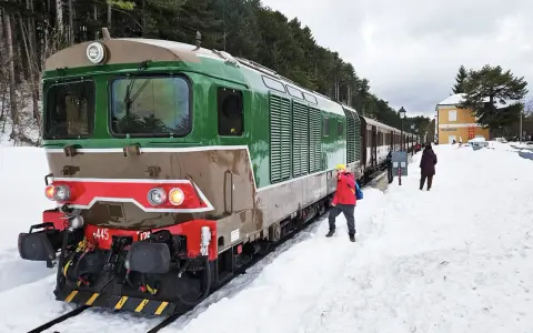 Treno della Transiberiana d'Abruzzo in sosta, con passeggeri sulla neve. Le tappe di questo viaggio unico tra montagne innevate.