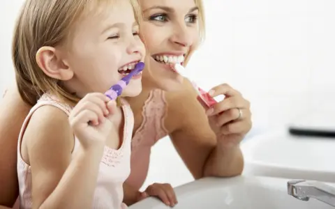 Mama uczy córkę myć zęby. Nie chcemy, by dzieci które nie myją zębów miały próchnicę!