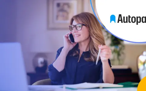 Kobieta rozmawia przez telefon, trzymając długopis. Logo Autopay obok. Dowiedz się, autopay co to jest.