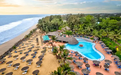 Rajskie wakacje w Gambii: plaża, basen i palmy tworzą idealne miejsce na relaks.