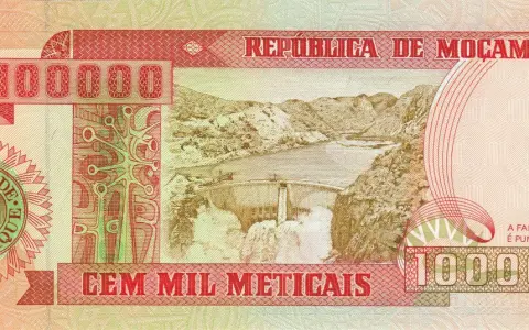 Banknot 100 000 meticali z Mozambiku. Widok na zaporę wodną i góry.