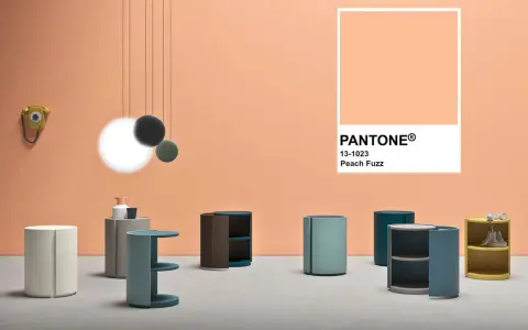 Arredamento moderno su sfondo color pesca Pantone. Tavolini cilindrici e un telefono vintage.