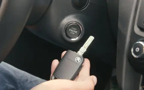 Słaba bateria w kluczyku może utrudnić odpalanie auta. Kluczyk z logo Skody leży w dłoni obok przycisku Start/Stop.