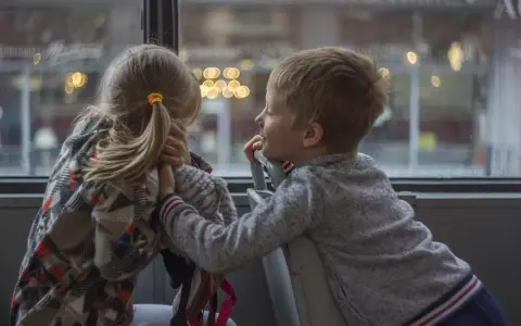 Dzieci rozmawiają przy oknie, planując kolejne atrakcje dla dzieci w Kielcach.