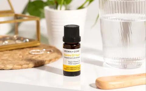 Un flacon de vitamine D3 vegan, un remède de grand-mère pour pallier le manque de vitamine D, à côté d'un verre d'eau.