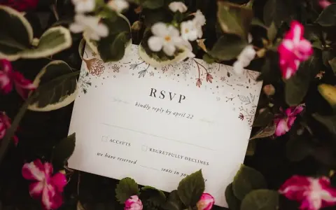 Karta RSVP z kwiatowym wzorem wśród zieleni i różowych kwiatów.