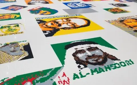 Portraits de personnalités réalisés en briques Lego, dans le style d'Ai Weiwei. L'œuvre est étendue sur un sol blanc.
