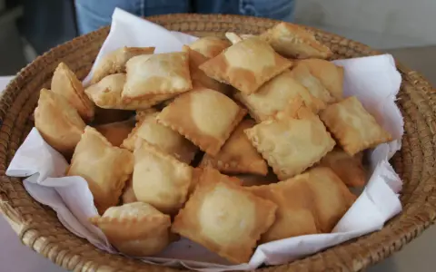Un panier rempli de beignets dorés, une spécialité des Hautes-Alpes, prêts à être dégustés.