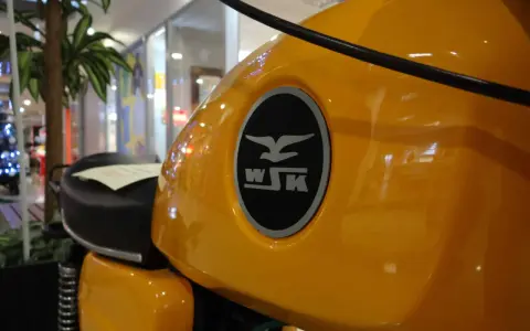 Żółty bak motocykla WSK 125 z charakterystycznym logo. Ile koni kryje się pod tą błyszczącą karoserią?