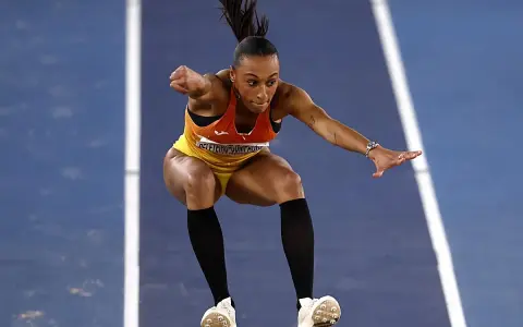Ana Peleteiro en pleno triple salto, concentrada y en el aire, lista para aterrizar.